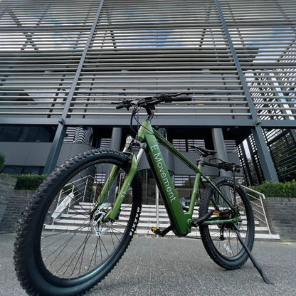 E-Movement Thor green hardtail e-bike – authentic manufacturer photograph outside a contemporary building